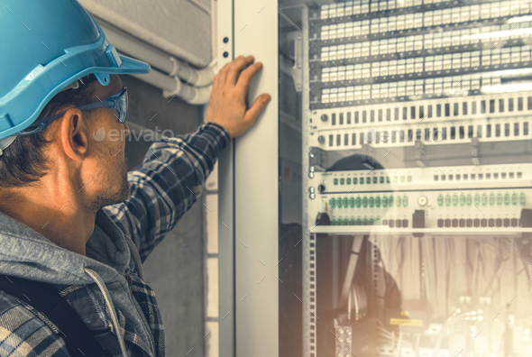 Telecommunication Technician Looking Inside Servers Rack - Stock Photo - Images