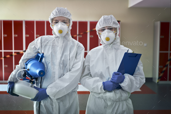 Portrait of two woman in disinfection suits ready for disinfection