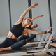 Using gym equipment. Two women in sportive wear and with slim