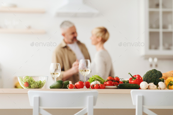 Happy loving couple, romantic dance on date in modern kitchen, smiling husband and wife celebrate
