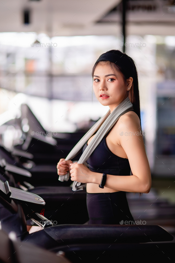 Young healthy woman on treadmill workout in gym