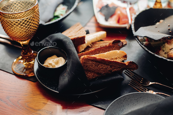 Snack with sauce on black plate with napkin - Stock Photo - Images