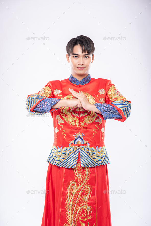 Man wear cheongsam smile and is standing and respect customer who come to shop in chinese new year