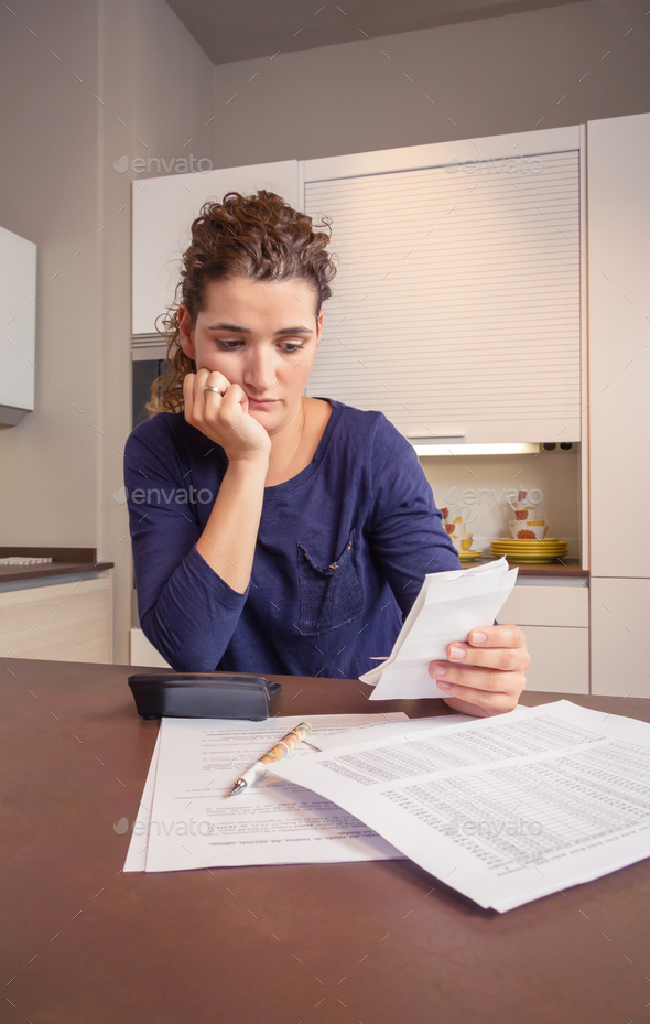 Unemployed and divorced woman with debts reviewing her monthly bills