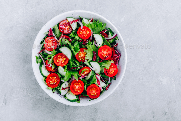 Green salad bowl with tomatoes, cucumbers, red onions, radicchio and fresh lettuce. - Stock Photo - Images