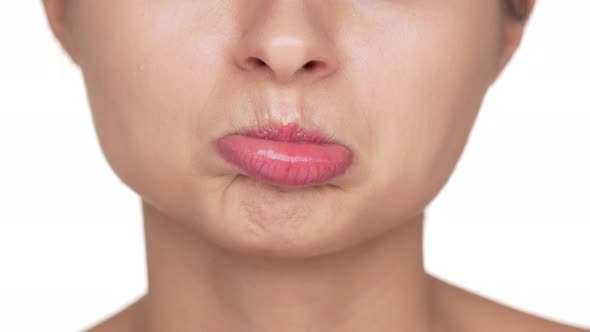 Macro View of Adult Woman with Healthy Clean Skin and Natural Makeup Twisting Her Lips Being Upset alt