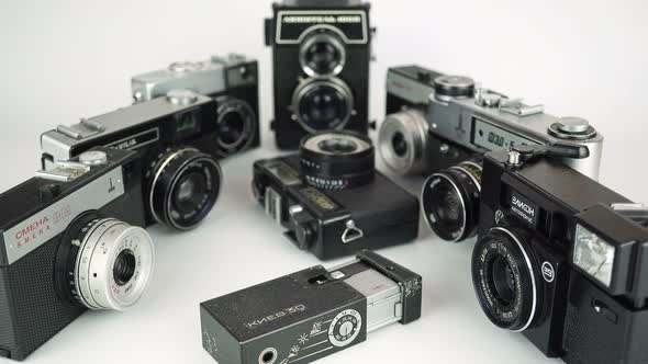 Zooming In On Old Film Cameras On A White Background 1. 
