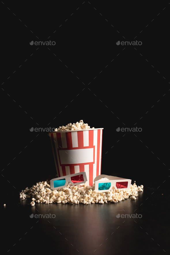 classic bucket of popcorn with 3d glasses on black