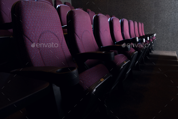 rows of red seats in empty dark cinema