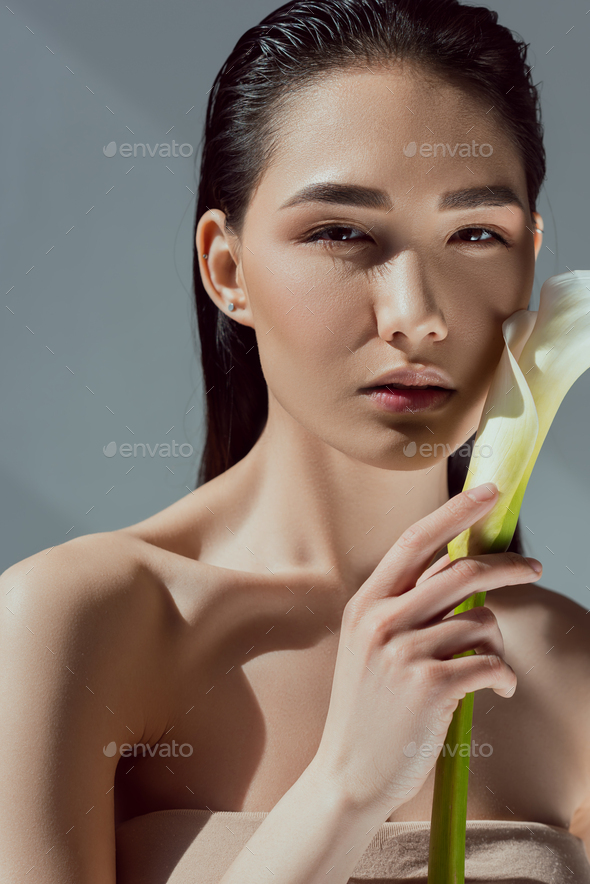 Attractive Naked Asian Woman With Calla Flower Isolated On Grey Stock