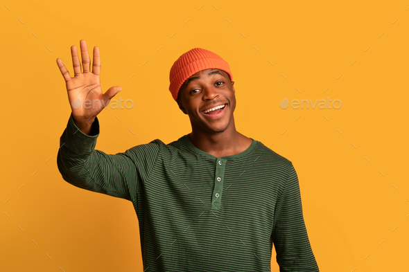 Hello. Portrait Of Friendly Young African American Guy Waving Hand At Camera
