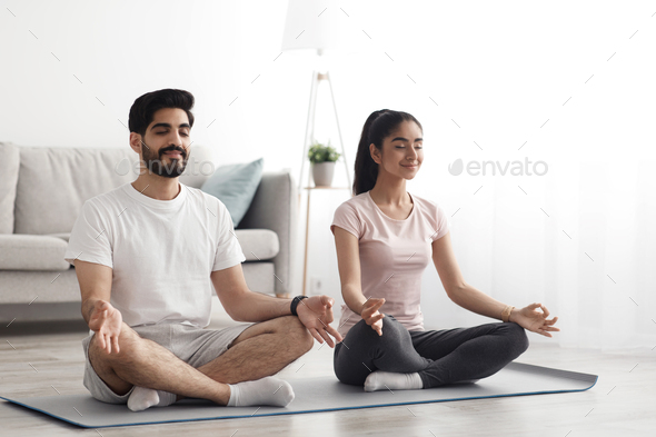 Happy couple doing exercises on quarantine at home, self-isolation together, stretching, exercise - Stock Photo - Images