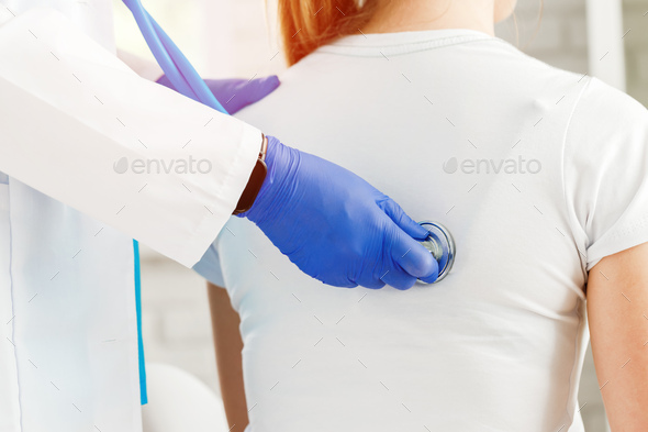 Doctor hands with stethoscope listening to heartbeat of woman patient
