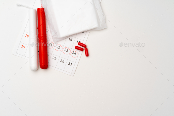 Menstruation calendar with sanitary pads and tampons, pills - Stock Photo - Images