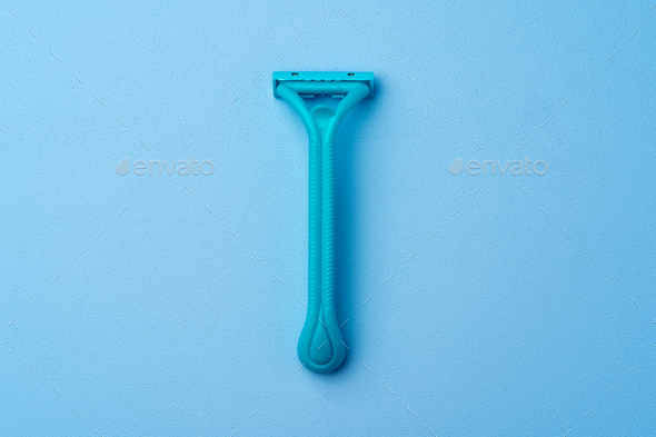 Single disposable razor for women on blue background