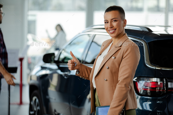 Portrait Of Beautiful Young Saleswoman In Suit Standing Inside 