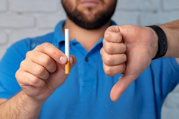 Man in blue short gesturing smoking is bad