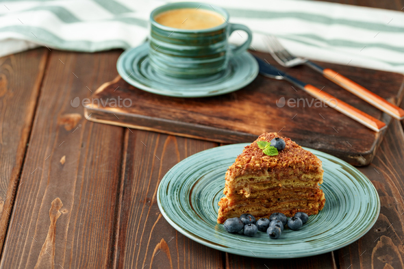 Piece of honey cake with nuts on green plate