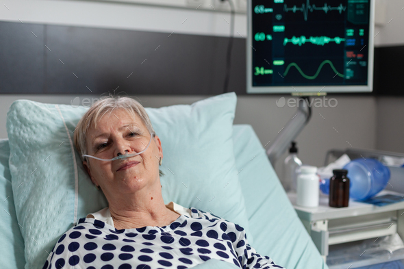 Senior woman patient laying in hospital bed following recovery treatment  Stock Photo by DC_Studio