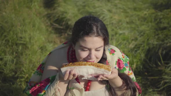 Portrait of Beautiful Overweight Woman Sitting in Grass Sniffing Tasty Lard Preparing To Eat alt