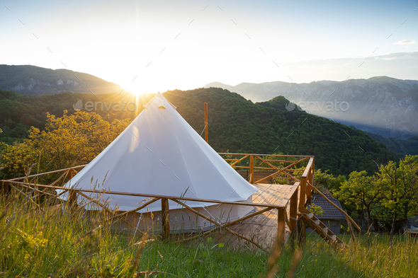 glamping tent in the morning sunlight with mountain range panorama - Stock Photo - Images