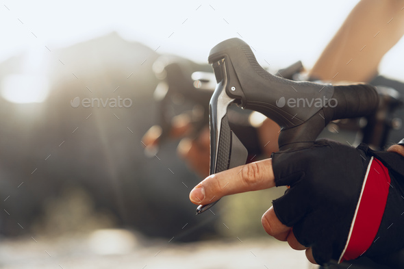 Hands of a professional cyclist in gloves on handle bar of a bicycle