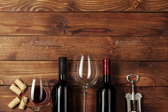 Red wine bottle, wine glass and corkscrew on wooden table background Stock  Photo by FabrikaPhoto
