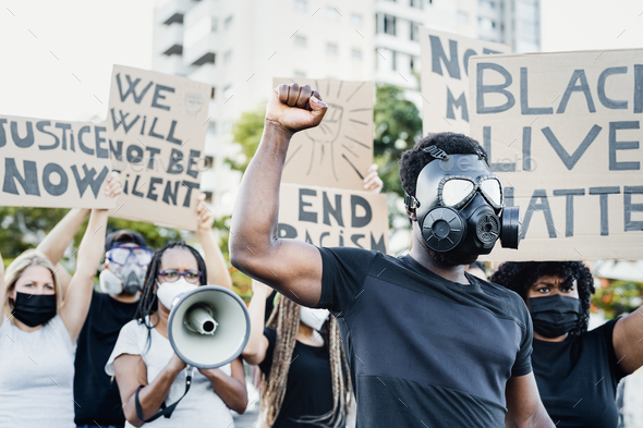 Activist wearing gas mask protesting against racism and fighting for equality - Stock Photo - Images