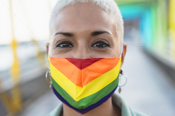 Portrait young woman wearing gay pride mask symbol of Lgbtq social movement