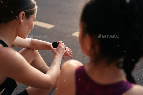 Portrait of two young beautiful sport woman resting after workout in the city