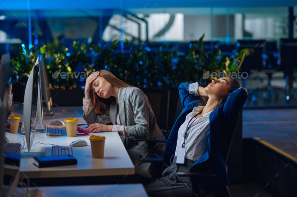 Tired women works on computers in night office - Stock Photo - Images