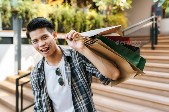 Cheerful Handsome man with shopping bag and credit card