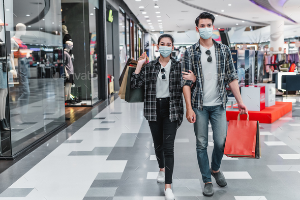 Young couple holding multiple shopping paper bag at mall - Stock Photo - Images