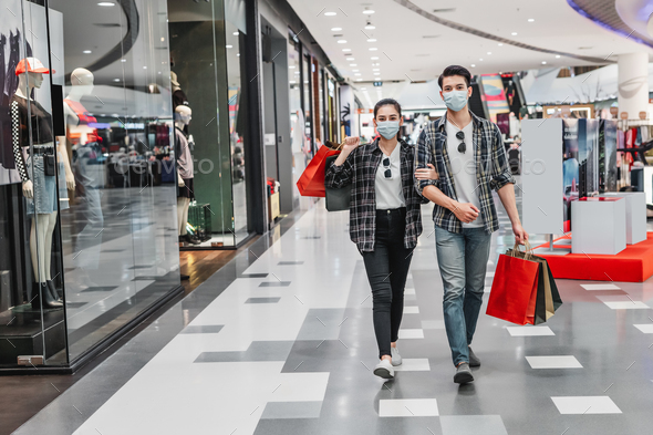 Young couple holding multiple shopping paper bag at mall - Stock Photo - Images