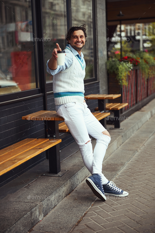 Joyful male person taking paper cup with coffee Stock Photo by Iakobchuk