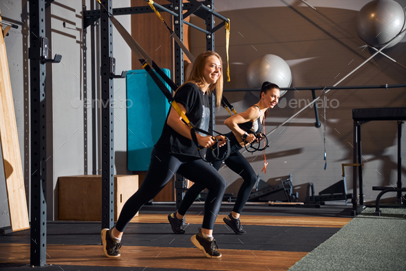 Two pretty women working out together at the gym Stock Photo by