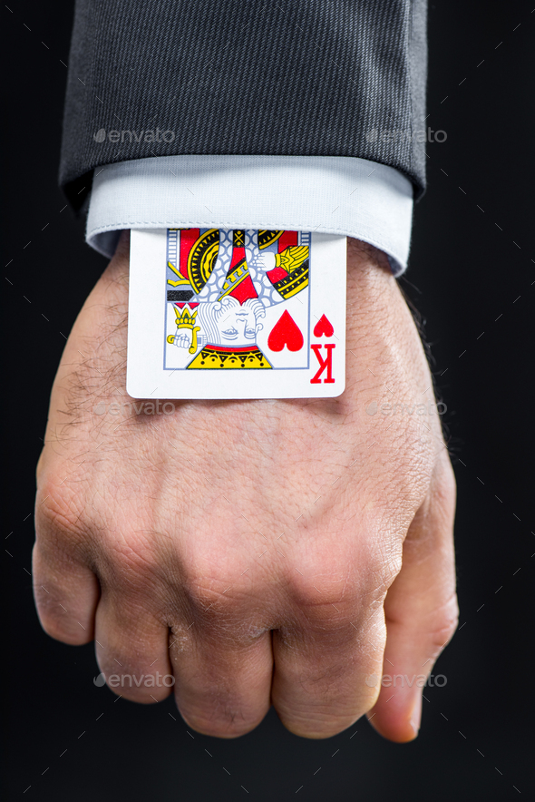 King of hearts playing card hidden in sleeve isolated on black