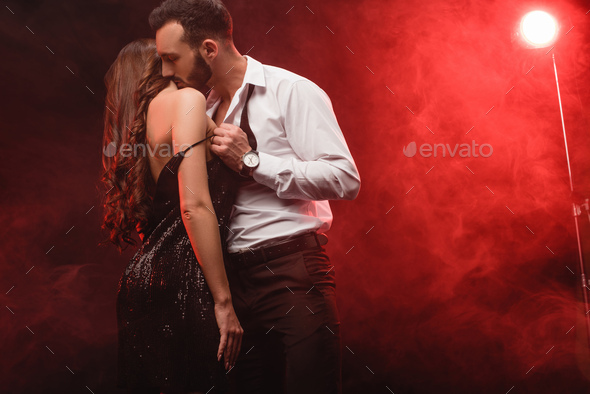 passionate seductive couple in red smoky room