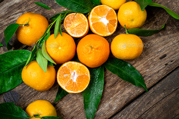 Fresh Clementine Mandarin Oranges fruits or Tangerines with leaves on  wooden background Stock Photo by nblxer
