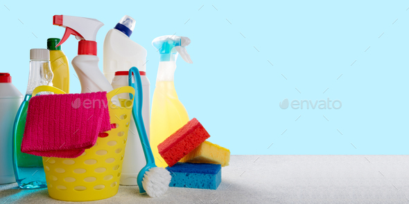 Basket with cleaning products on blue background. Cleaning with