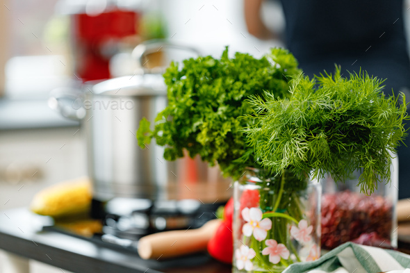 Kitchen counter with stove and parsley bundle on foreground