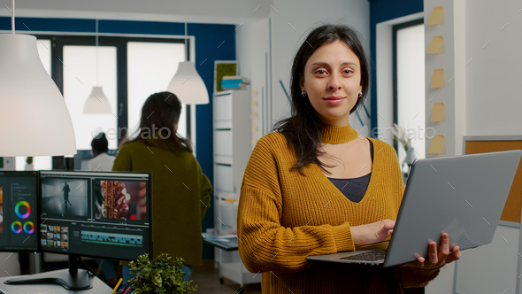Woman retoucher looking at camera smiling working in creative media agency
