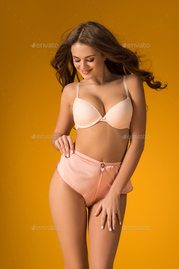 sexy girl posing in lingerie set and looking down on orange - Stock Photo -  Dissolve