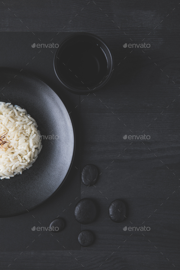 Top View Of Rice On Plate With Cup Of Tea On Black Table Stock Photo By Lightfieldstudios