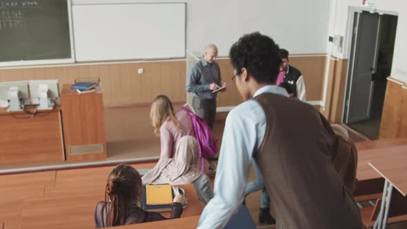Multiethnic Students Taking their Seats in Auditorium before Lesson alt