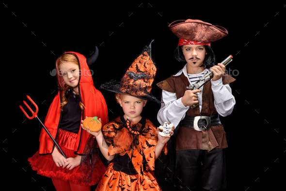 kids in halloween costumes of devil, witch and pirate posing isolated on black