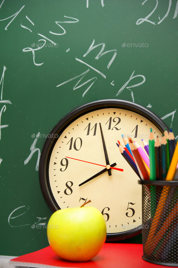 Watch, an apple and felt-tip pens against a school board. - Stock Photo - Images