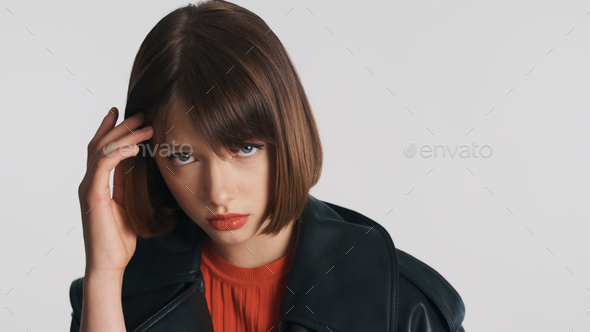 Upset girl with bob hair and red lips looking shy on camera. Sad face expression