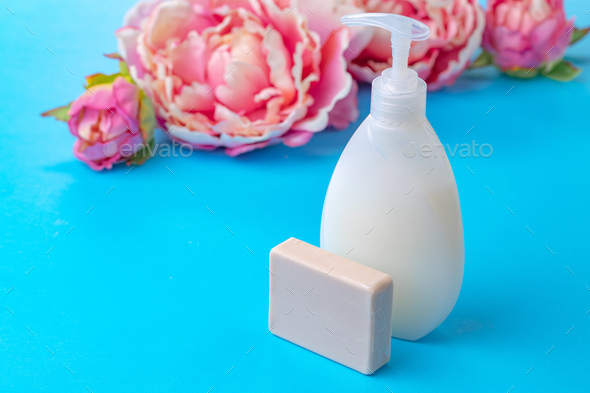 Liquid soap in clear bottle on color background