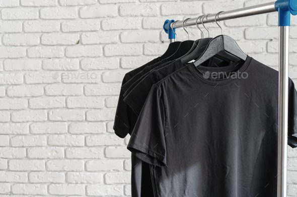 T-shirts on hangers against brick wall Stock Photo by ©belchonock 134831422